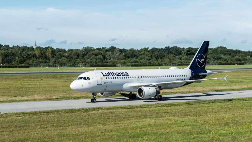 A Lufthansa Airbus A320 jet taxiing on a sunny day at Hamburg Airport, Germany.