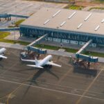 Aerial view of Abeid Amani Karume International Airport in Zanzibar, showing parked airplanes and terminal.