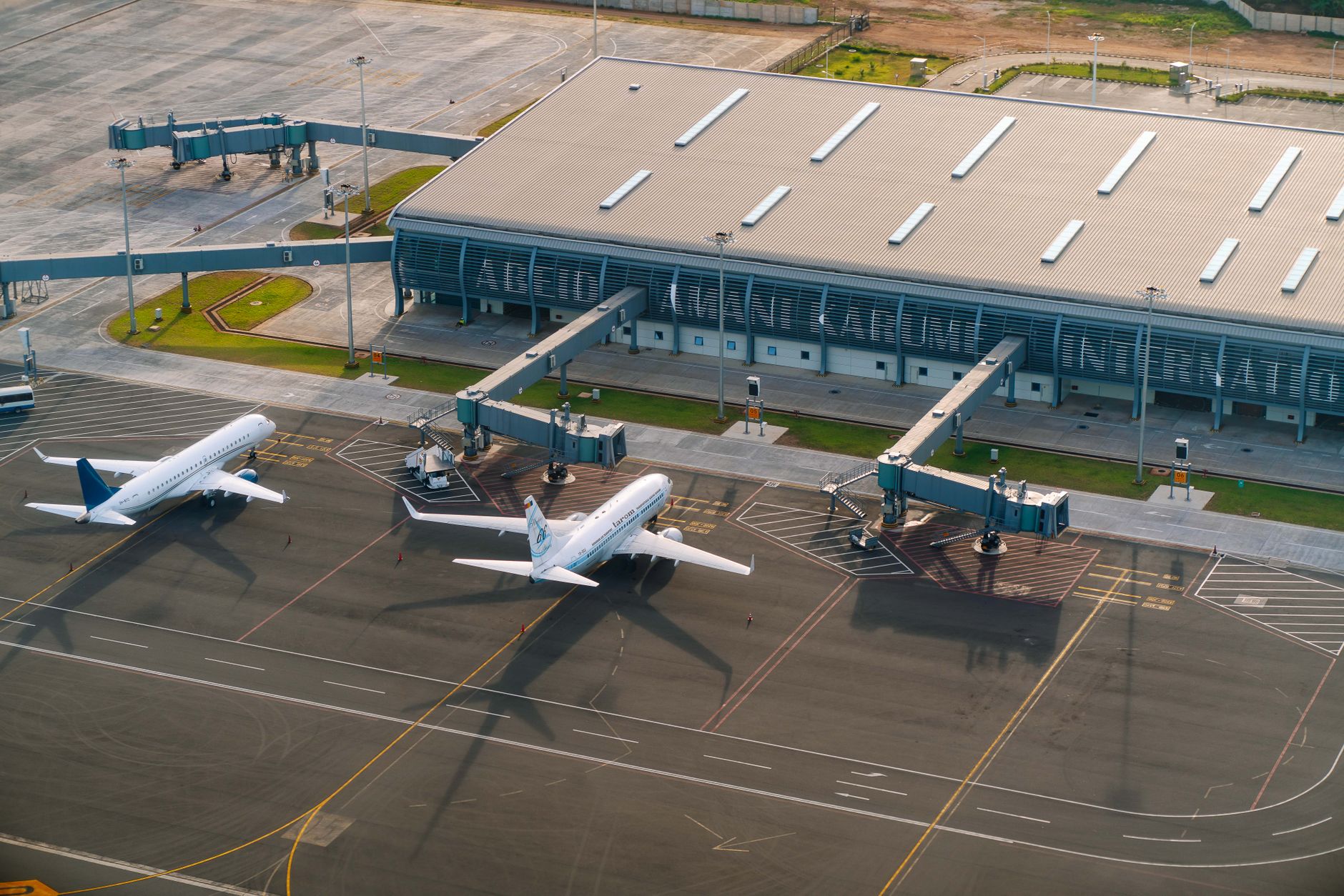 Aerial view of Abeid Amani Karume International Airport in Zanzibar, showing parked airplanes and terminal.