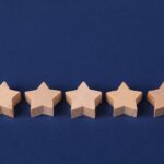 Five wooden stars on a blue background representing a rating system or evaluation concept.