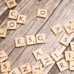 Wooden letter tiles spell ESG on a rustic wooden surface, emphasizing sustainability.