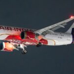 Air India Airbus A320 aircraft photographed during night flight with landing lights on.