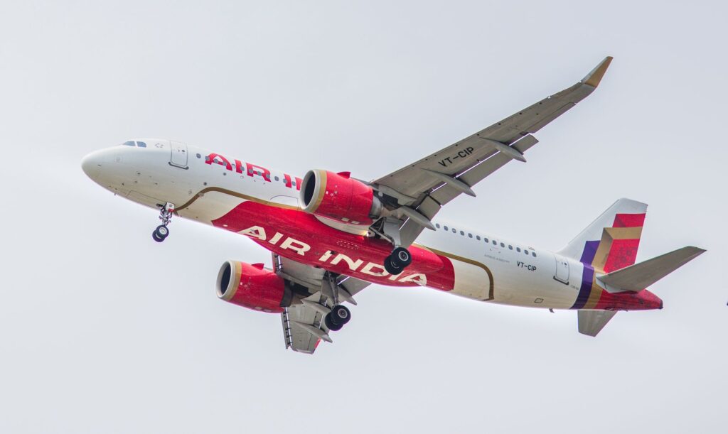 A close-up shot of an Air India airplane flying in the sky, showcasing its design and flight details.