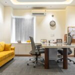 A bright and modern office space featuring a cozy yellow sofa and sleek furniture in Punjab, India.