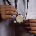 A close-up image showing a doctor holding a stethoscope, symbolizing healthcare and medical practice.