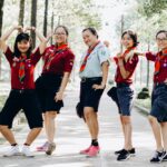 A cheerful group of scouts posing in a park with vibrant uniforms and energetic gestures.