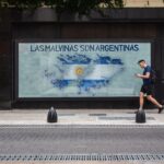 A person walks by a mural depicting the Falklands map with Argentine text in Buenos Aires.