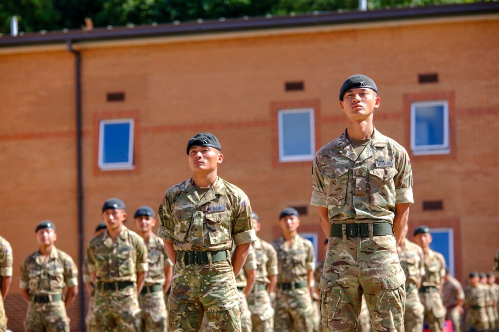 Gurkha soldiers stand in formation at a military base in England, UK on a sunny day.