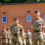 Gurkha soldiers stand in formation at a military base in England, UK on a sunny day.