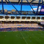 A lively football match in Stamford, England capturing the crowd and players in a filled stadium.