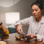 Two friends play poker with chips and whiskey on a wooden table.