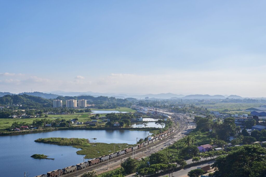 Aerial view of a lush landscape with railroads and water bodies in Assam, India.