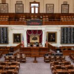 The Texas House of Representatives chamber, featuring legislative seats and historical portraits.