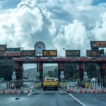 View of vehicles approaching the toll plaza at Golden Gate Bridge in San Francisco under a cloudy sky.
