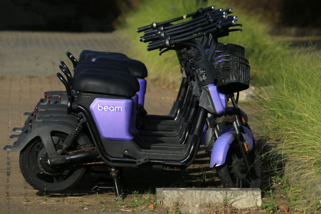 Purple Beam e-scooters parked in a row on a sunny day, ideal for urban transport themes.