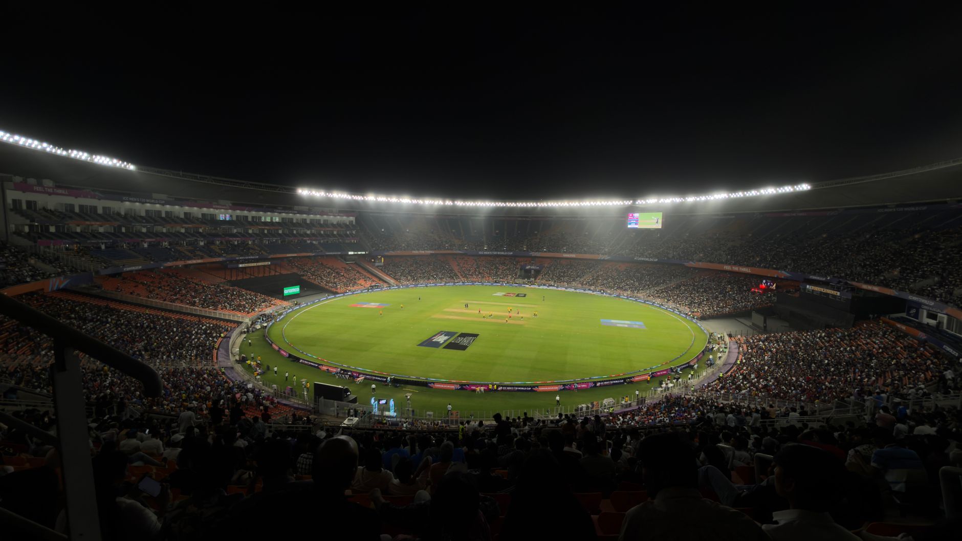 A captivating night cricket match with a large crowd at Narendra Modi Stadium in Ahmedabad, India.