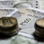 Detailed close-up of Indian rupee coins on top of banknotes, representing finance.