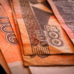Macro shot of Cambodian Riel banknotes in a fanned arrangement displaying intricate designs and denominations.