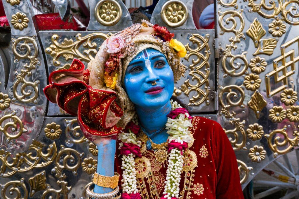 A vibrant portrayal of a person dressed as Lord Krishna during a festival celebration in Dhaka, Bangladesh.