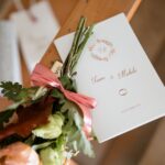 A wedding invitation and bouquet on display, signifying a special day.