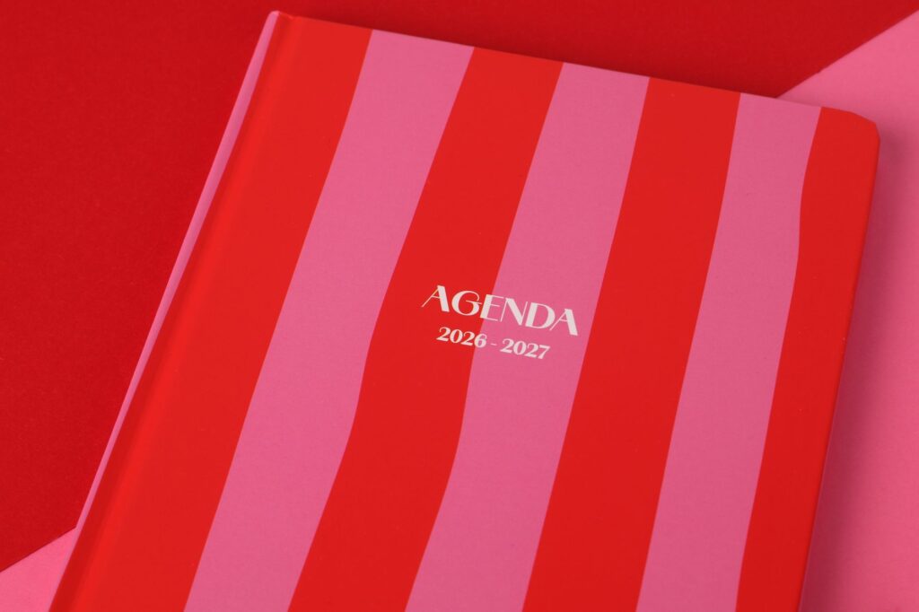 Red and pink striped agenda book for 2026-2027, perfect for planning.