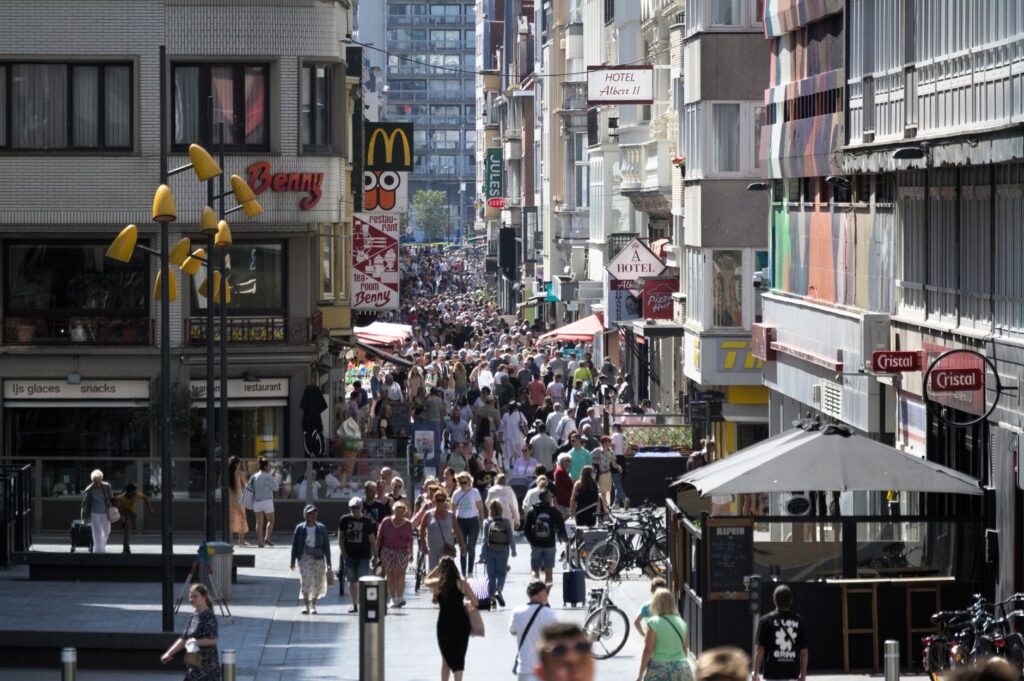 Busy commercial street in Ostend, Belgium bustling with pedestrians and iconic signage.