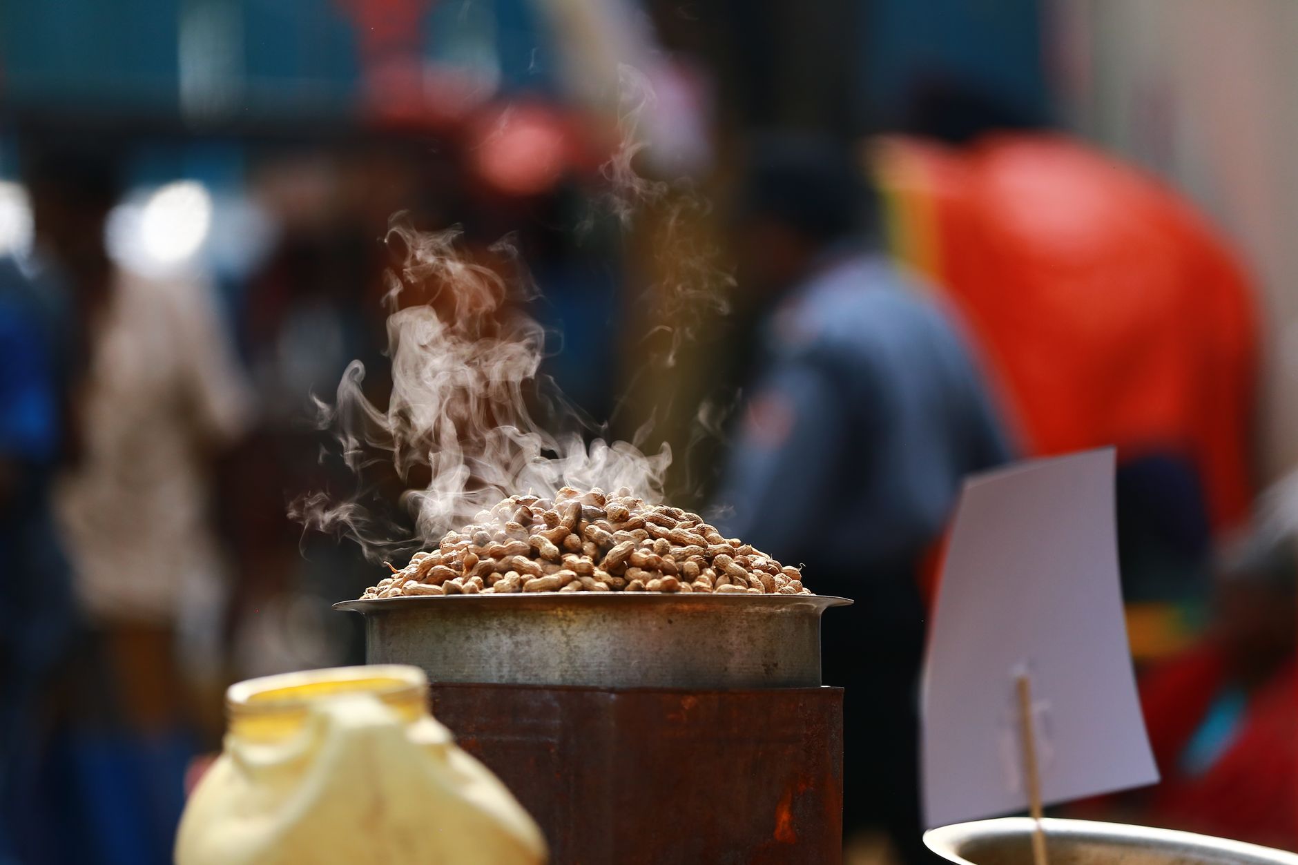 Freshly roasted peanuts steaming atop a street stall in Bengaluru, India.