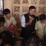 Teacher guiding attentive students during an interactive indoor lesson, fostering education.