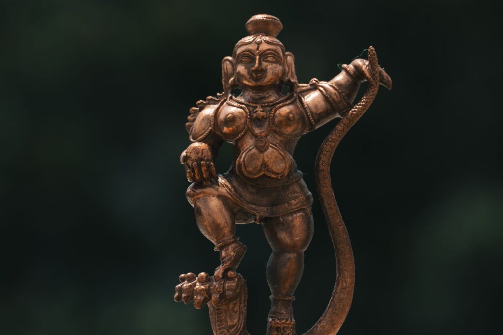 A detailed brass sculpture of a Hindu deity, showcasing traditional craftsmanship, located outdoors in Bengaluru, India.
