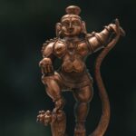 A detailed brass sculpture of a Hindu deity, showcasing traditional craftsmanship, located outdoors in Bengaluru, India.