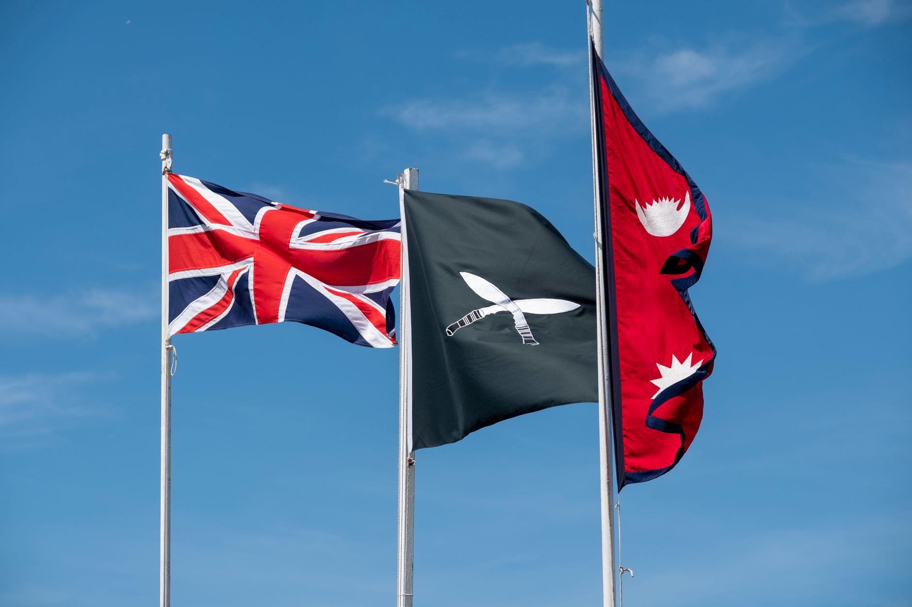 Union Jack, Gurkha and Nepal flags waving in Aldershot, England.