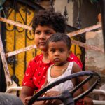 Two children sitting on a rickshaw in Rohtak, India displaying joy and innocence.