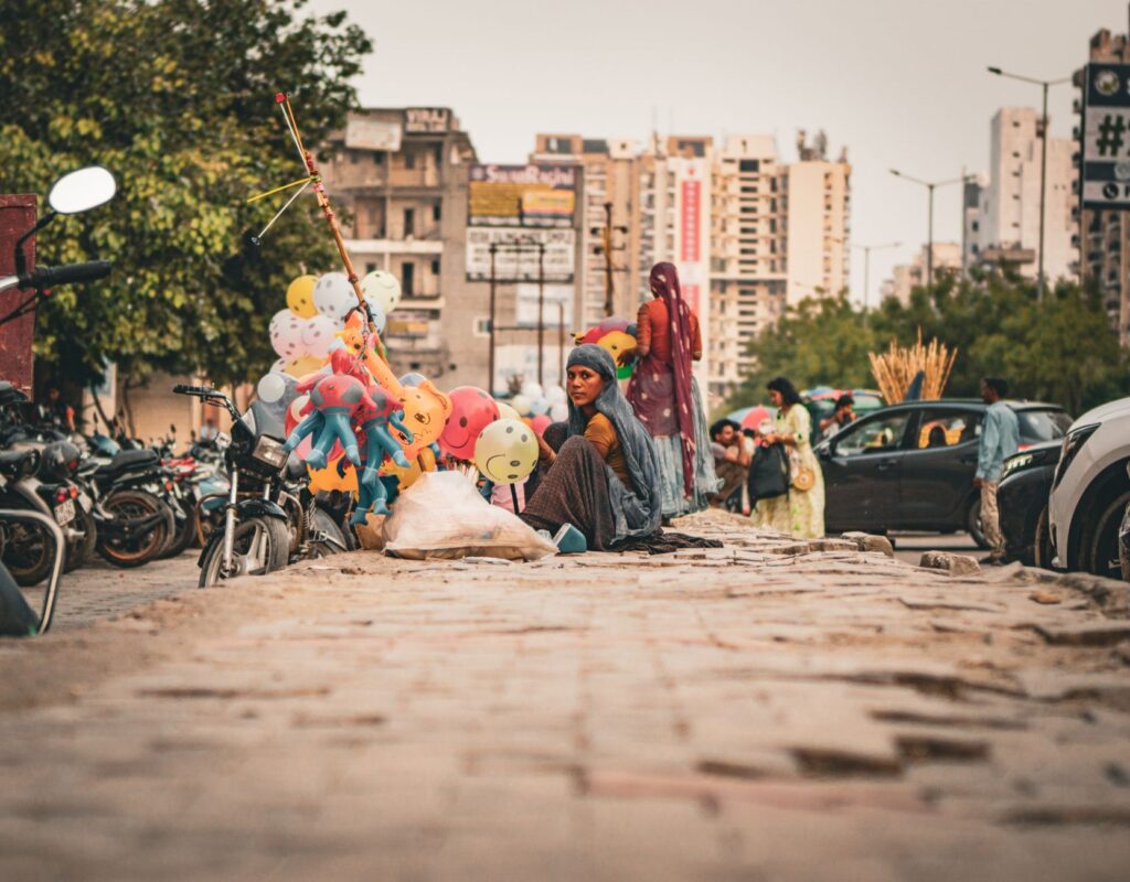 A street vendor selling colorful balloons amidst city traffic, capturing urban life.
