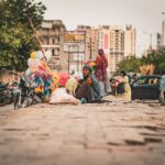 A street vendor selling colorful balloons amidst city traffic, capturing urban life.
