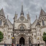 Exterior of the Royal Courts of Justice in London with cloudy skies.
