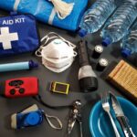 Flat lay of essential emergency survival kit items including first aid and water bottles.