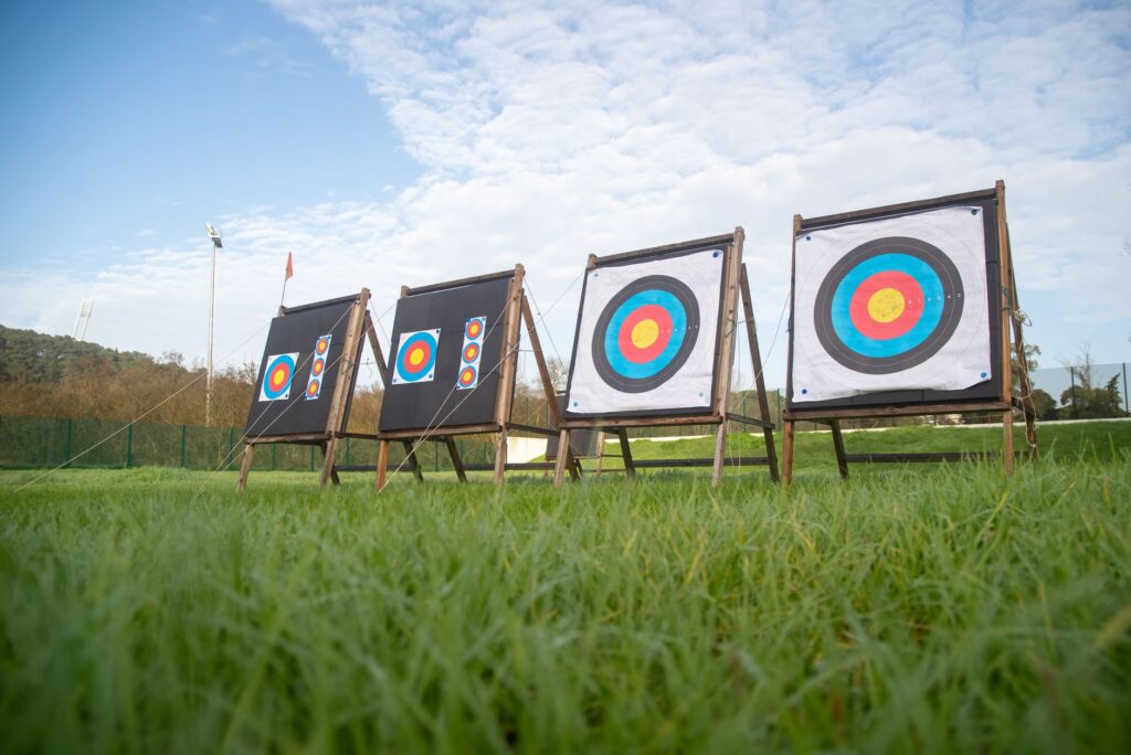 View of archery targets set up on a lush green field with a clear sky.
