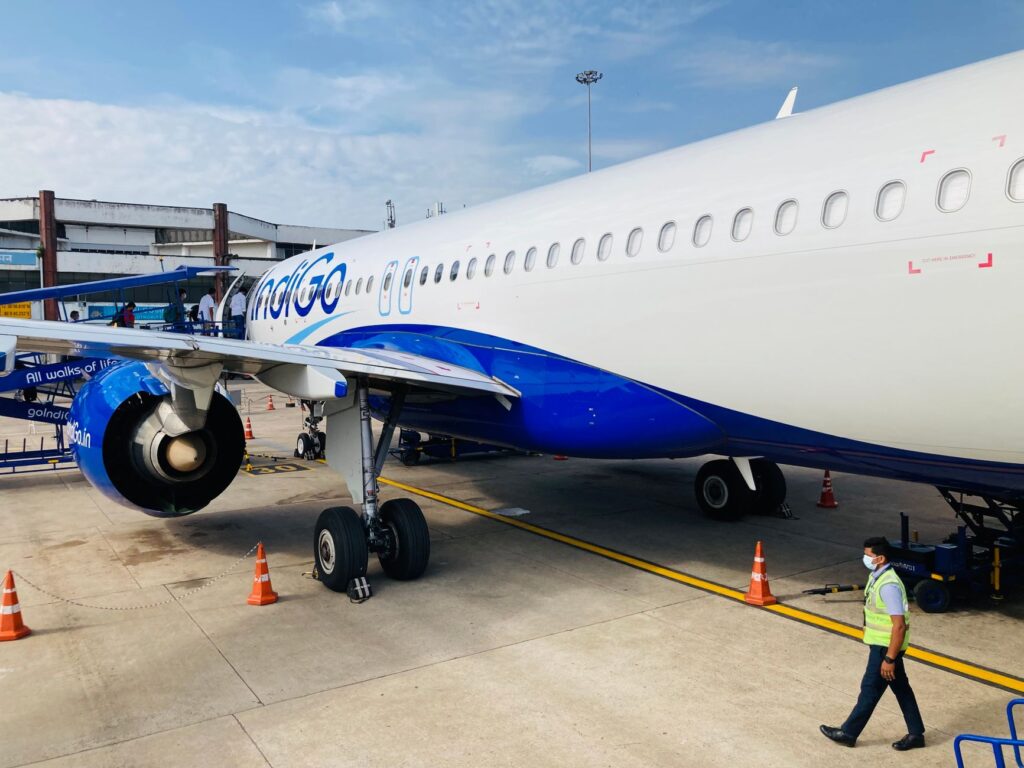 A commercial aircraft on the tarmac at Chennai airport, India. Blue and white airplane ready for boarding.