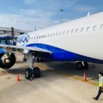 A commercial aircraft on the tarmac at Chennai airport, India. Blue and white airplane ready for boarding.
