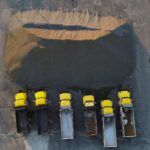 Drone shot of yellow trucks aligned by a gravel heap in New Bern, NC, showcasing industrial work.