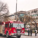 A vibrant red fire truck on duty in a bustling street in Beijing, China.