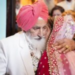 A heartfelt embrace between an elderly man and a bride during a traditional wedding ceremony.