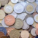 Colorful collection of international coins in various denominations and currencies.