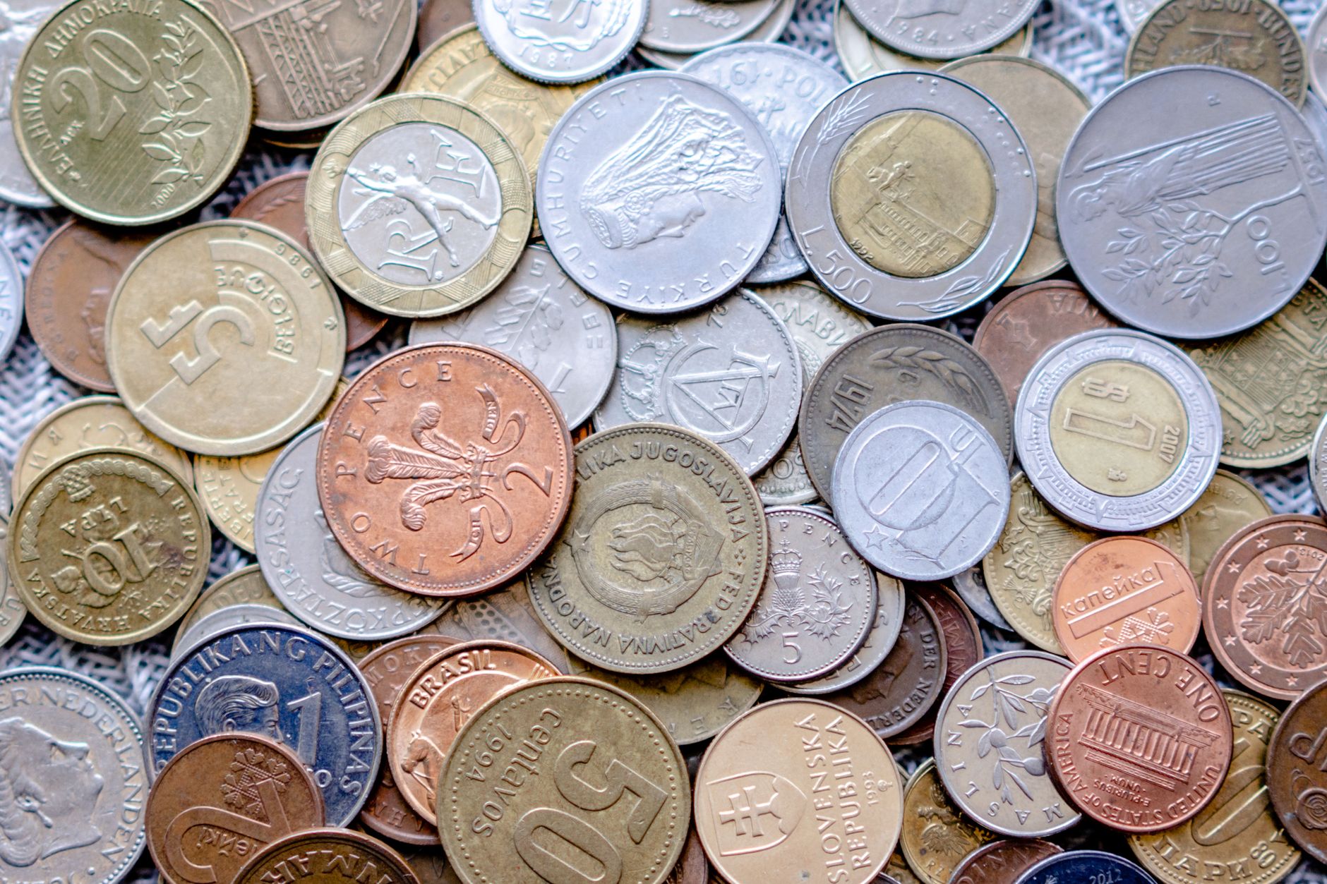 Colorful collection of international coins in various denominations and currencies.