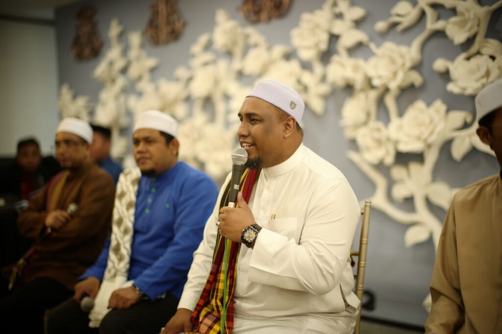 Muslim men in traditional attire engage in a religious gathering in Kuala Lumpur, Malaysia.