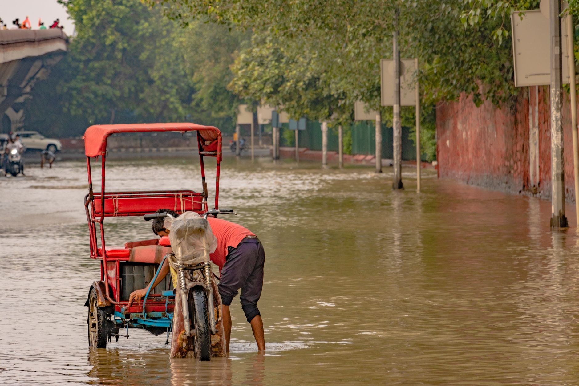 A rickshaw navigates a flooded street in New Delhi, India, during the 2023 monsoon.