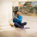 Man playing flute on the streets of Delhi, India. Capturing the essence of urban street music.