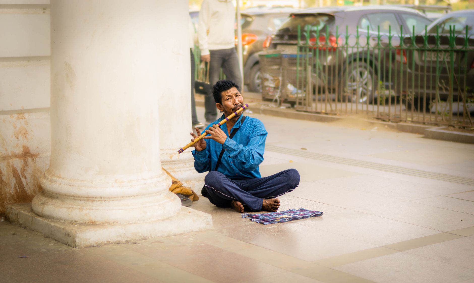 Man playing flute on the streets of Delhi, India. Capturing the essence of urban street music.