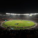 A captivating night cricket match with a large crowd at Narendra Modi Stadium in Ahmedabad, India.