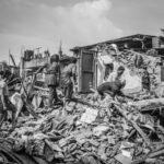 Black and white image of people amidst earthquake ruins in Bhaktapur, Nepal.